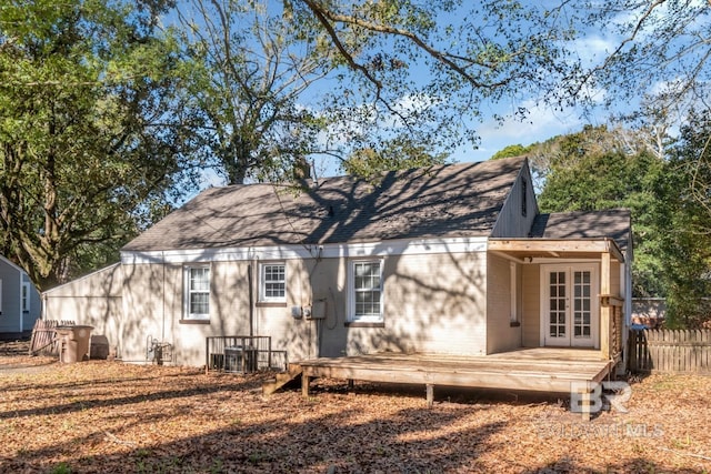 rear view of house featuring french doors, a shingled roof, fence, and a wooden deck