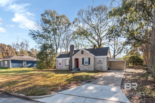 view of front facade with driveway, a chimney, an attached carport, crawl space, and a front lawn