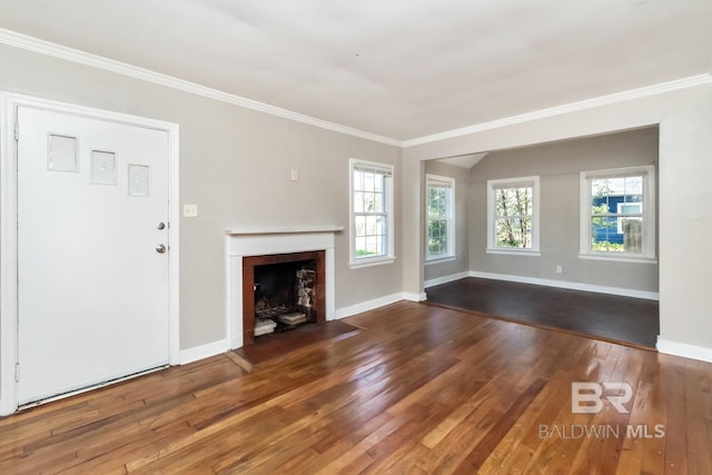 unfurnished living room with a healthy amount of sunlight, wood-type flooring, ornamental molding, and baseboards