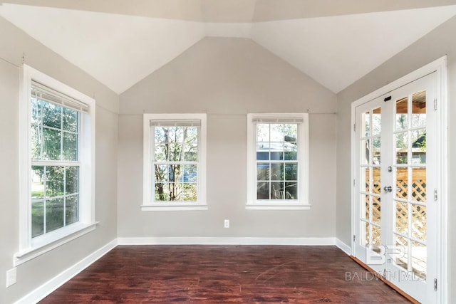 unfurnished room with vaulted ceiling, dark wood-style flooring, and baseboards