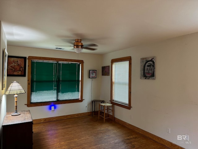 unfurnished room with ceiling fan and dark hardwood / wood-style flooring