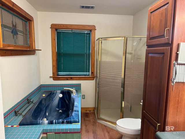 bathroom featuring hardwood / wood-style floors, toilet, and independent shower and bath