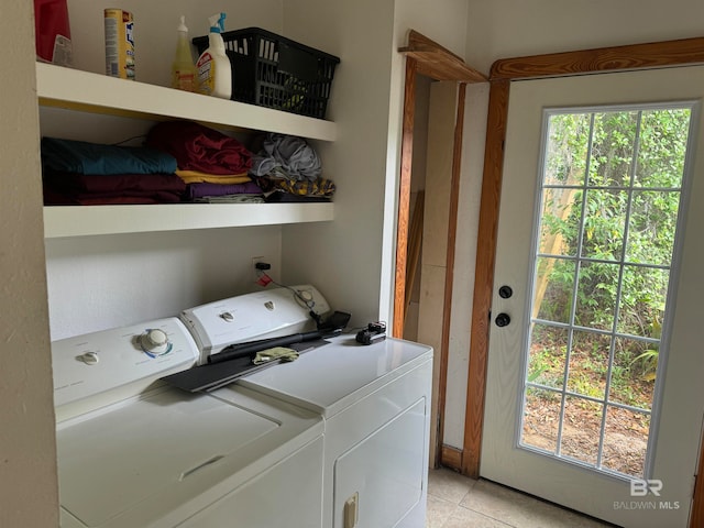 clothes washing area featuring light tile patterned floors and washing machine and clothes dryer