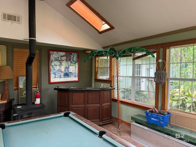 rec room with plenty of natural light, a wood stove, billiards, and vaulted ceiling