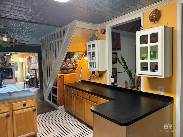 kitchen with kitchen peninsula, crown molding, and light hardwood / wood-style floors