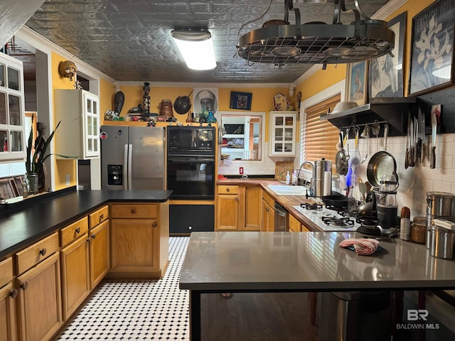 kitchen with backsplash, black appliances, sink, ornamental molding, and a kitchen bar