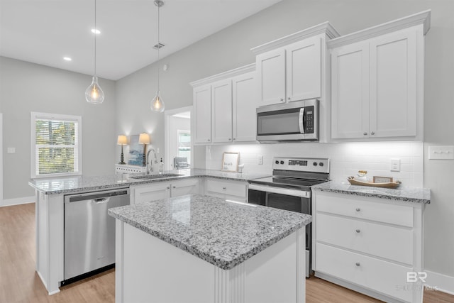 5774 Ono Ave, Pensacola, FL 32507 - kitchen with appliances with stainless steel finishes, a sink, a peninsula, light wood finished floors, and white cabinets