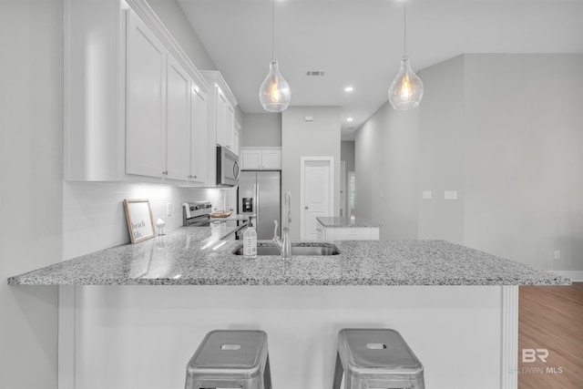 5774 Ono Ave, Pensacola, FL 32507 - kitchen featuring appliances with stainless steel finishes, a peninsula, white cabinetry, backsplash, and a sink