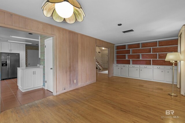 52 N Hawthorne Pl, Mobile, AL 36608 - unfurnished living room featuring wood walls, stairway, and wood finished floors