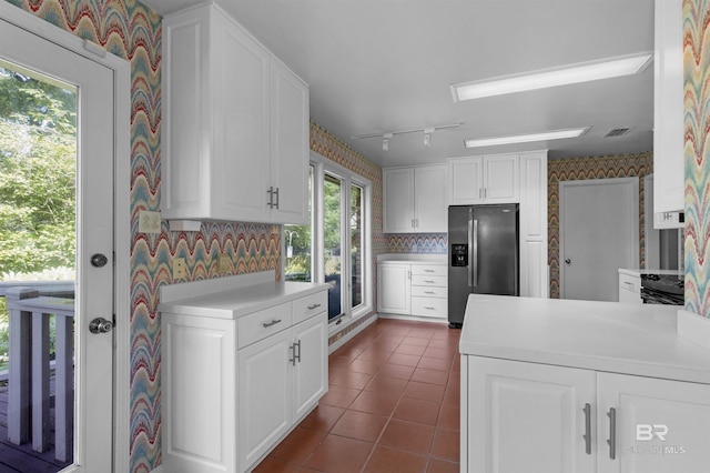 52 N Hawthorne Pl, Mobile, AL 36608 - kitchen with stainless steel fridge with ice dispenser, wallpapered walls, dark tile patterned floors, white cabinetry, and light countertops