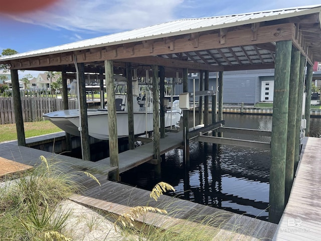 dock area featuring boat lift, fence, and a water view