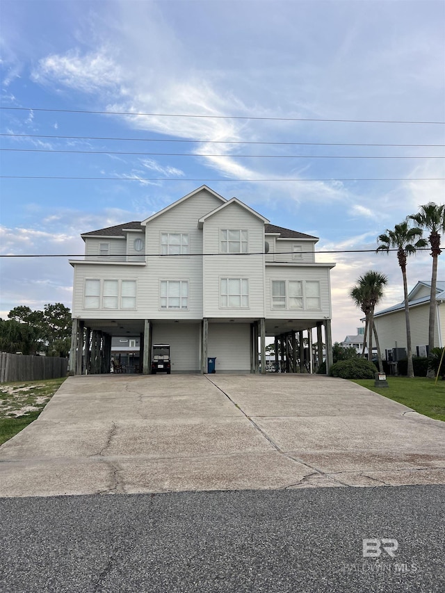 coastal inspired home featuring a carport and concrete driveway