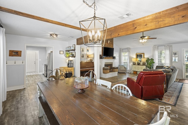 117 Richmond Rd, Daphne, AL 36526 - dining area featuring dark wood finished floors, a fireplace with raised hearth, beamed ceiling, a ceiling fan, and a chandelier