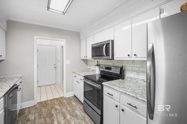 117 Richmond Rd, Daphne, AL 36526 - kitchen with stainless steel appliances, light wood-type flooring, tasteful backsplash, white cabinets, and baseboards