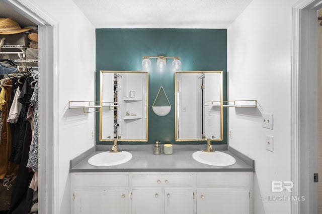 117 Richmond Rd, Daphne, AL 36526 - bathroom with double vanity, a spacious closet, and a textured ceiling
