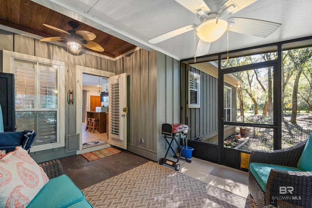 sunroom / solarium featuring ceiling fan