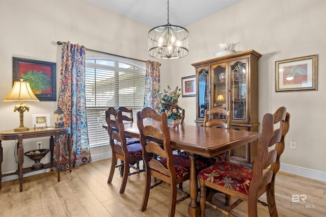 dining space with an inviting chandelier and light hardwood / wood-style flooring