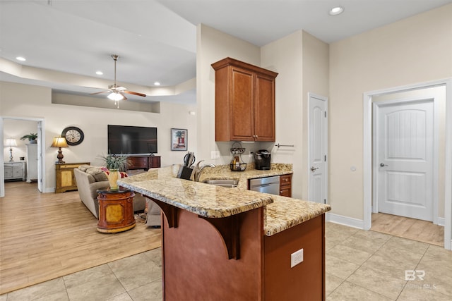 kitchen featuring a breakfast bar, dishwasher, light tile patterned floors, light stone counters, and kitchen peninsula