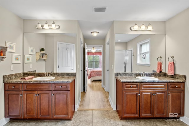 bathroom with walk in shower, tile patterned floors, and vanity