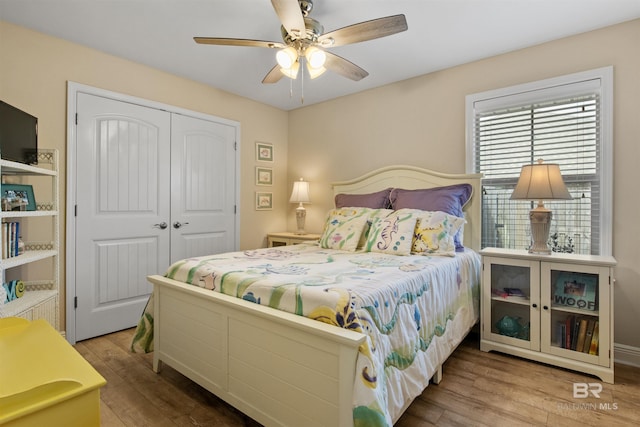 bedroom featuring hardwood / wood-style floors, ceiling fan, and a closet