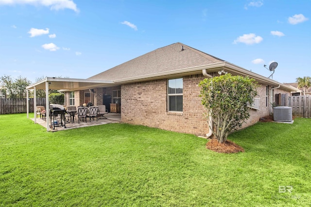 rear view of property with cooling unit, a yard, and a patio