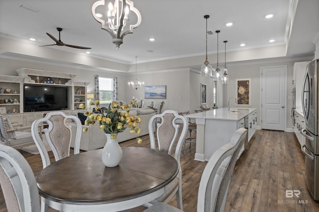 dining room with sink, crown molding, and dark wood-type flooring