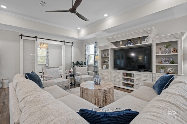 living room featuring hardwood / wood-style floors, ornamental molding, a barn door, and ceiling fan