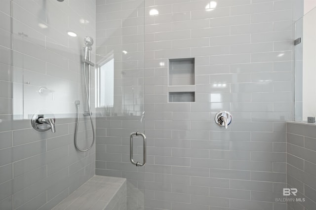 bathroom featuring a shower with door