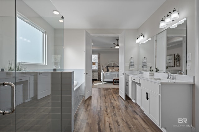 bathroom with vanity, hardwood / wood-style floors, a bath, and a healthy amount of sunlight