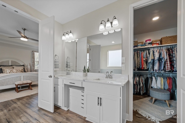 bathroom with a healthy amount of sunlight, ceiling fan, vanity, and wood-type flooring