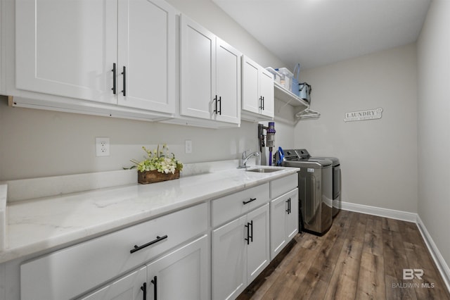 laundry room with dark hardwood / wood-style flooring, sink, cabinets, and washing machine and clothes dryer