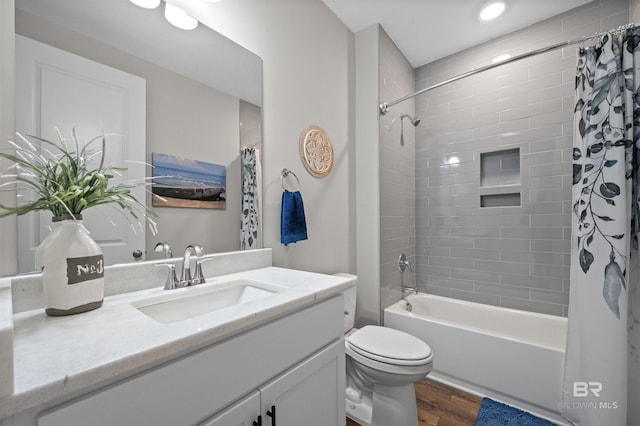 full bathroom featuring vanity, hardwood / wood-style floors, toilet, and shower / bathtub combination with curtain