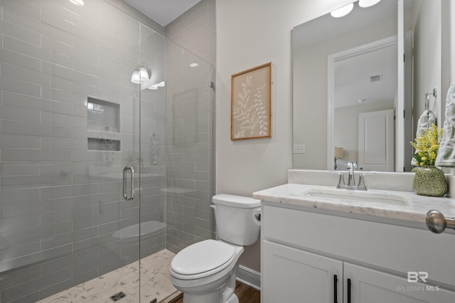 bathroom with vanity, an enclosed shower, and toilet