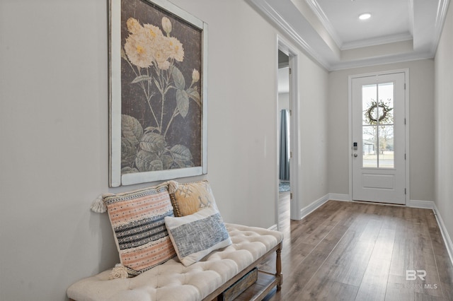 foyer featuring hardwood / wood-style flooring, ornamental molding, and a tray ceiling