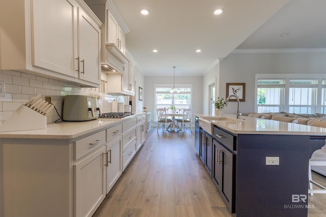 kitchen featuring a kitchen breakfast bar, backsplash, light wood finished floors, and white cabinetry