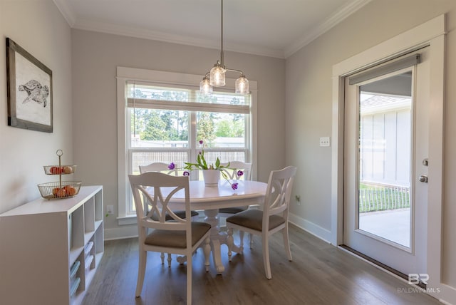 dining space featuring baseboards, ornamental molding, plenty of natural light, and wood finished floors