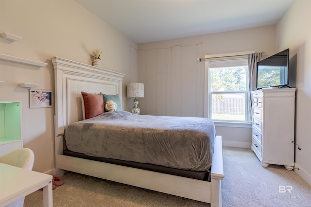 bedroom with light colored carpet and baseboards