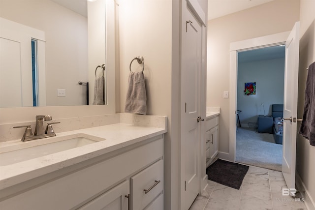 bathroom with baseboards, marble finish floor, and vanity