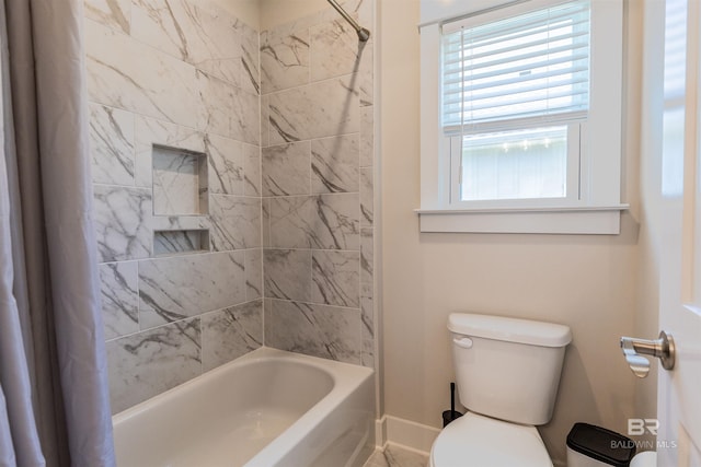 bathroom with baseboards, toilet, and shower / tub combo
