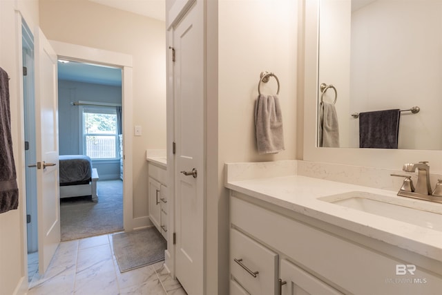 bathroom with vanity, ensuite bathroom, baseboards, and marble finish floor