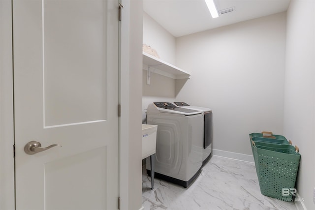 clothes washing area with laundry area, visible vents, washing machine and clothes dryer, baseboards, and marble finish floor