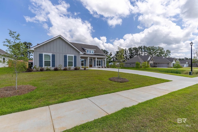 view of front of house with board and batten siding, curved driveway, covered porch, and a front lawn