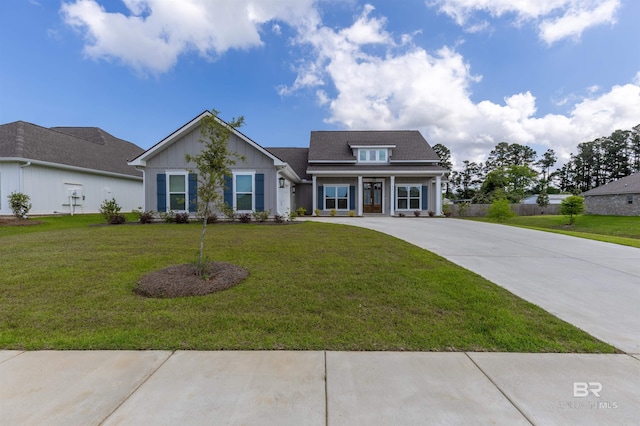 view of front of home featuring covered porch, board and batten siding, driveway, and a front lawn