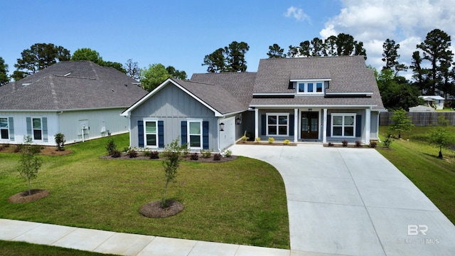 view of front of home with a garage, board and batten siding, driveway, and a front yard