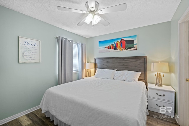 bedroom with ceiling fan, dark hardwood / wood-style flooring, and a textured ceiling