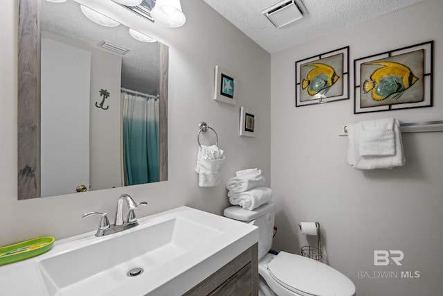 bathroom with a textured ceiling, toilet, and vanity