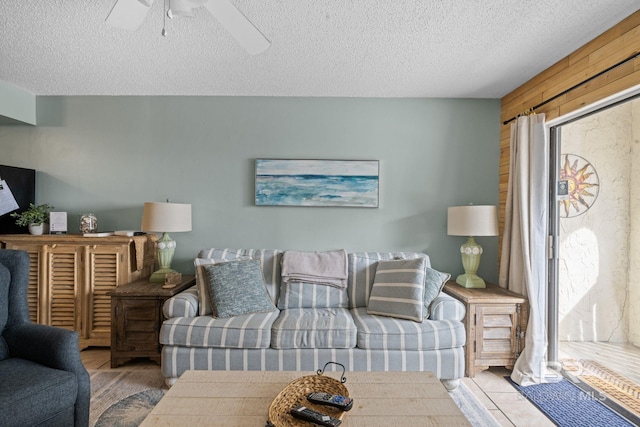 living room featuring ceiling fan and a textured ceiling