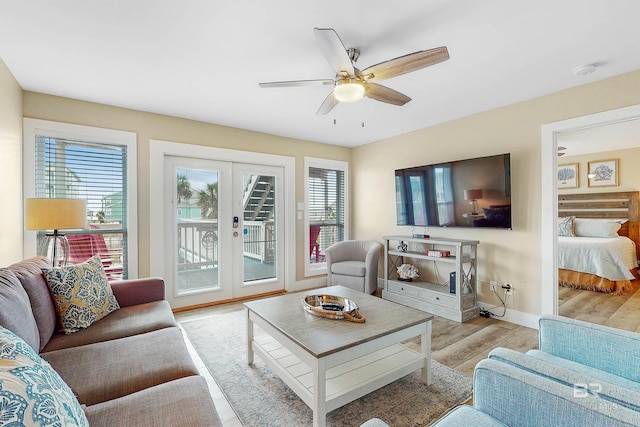 living room with ceiling fan, light wood-type flooring, and french doors