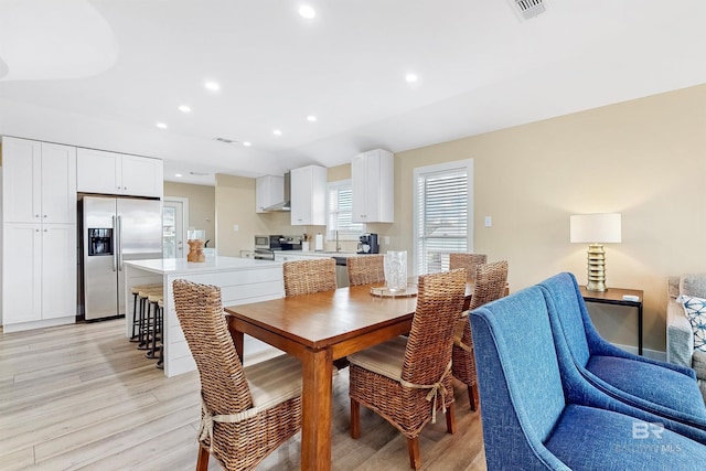 dining room with sink and light hardwood / wood-style flooring