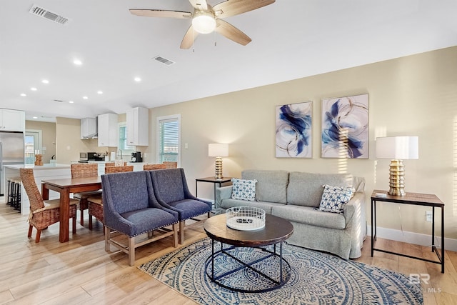 living room featuring ceiling fan and light wood-type flooring